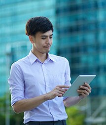 A male student walks with a tablet